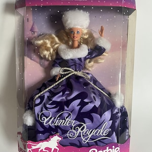 Puede incluir: Una muñeca Barbie Winter Royale de edición limitada con un vestido morado con estampado de hojas de color morado oscuro, ribete de piel sintética blanca en el cuello, puños y gorro, y un cinturón de cordón dorado. Tiene el cabello rubio.