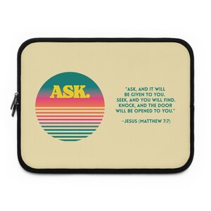 May include: A beige laptop sleeve with a black zipper border. The front features a circular graphic with horizontal stripes in teal, pink, and orange, containing the yellow text ASK. Next to it is the text: ASK, AND IT WILL BE GIVEN TO YOU.