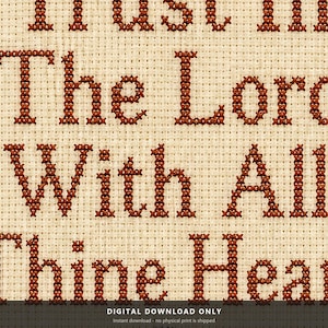 May include: A cross-stitch embroidery pattern on light beige Aida fabric featuring dark brown lettering. The visible text reads: Trust in The Lord With All Thine Heart. The letters are formed by individual X-shaped stitches in a uniform brown thread.