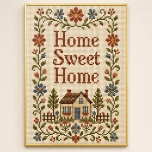 Puede incluir: Un bordado de punto de cruz en un marco dorado con el texto Home Sweet Home en letras de color rojo oscuro. El diseño está rodeado por un borde floral de flores rojas y azules con enredaderas verdes, y una pequeña casa con árboles abajo.