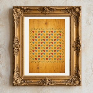 Op de afbeelding: Een rechthoekige print met een raster van kleine rode, blauwe en groene hartjes op een gele achtergrond met houtnerf, omringd door een dunne groene rankenrand. De print zit in een sierlijke, goudkleurige lijst met gedetailleerd snijwerk.