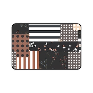 May include: A rectangular mat featuring a patchwork design of various patterns including black and white horizontal stripes, brown and white vertical stripes, black polka dots on brown, white polka dots on dark gray, and small floral motifs.