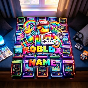 May include: A rectangular blanket featuring a vibrant, neon-colored graphic of a Roblox character wearing headphones and sunglasses, holding a game controller. The design includes multiple arcade game cabinets, a rainbow, and the text Roblox and Name.