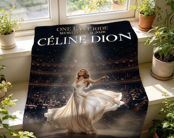 Könnte beinhalten: Eine rechteckige Fleecedecke mit einer Konzertszenen-Abbildung, die eine Sängerin in einem weißen Kleid auf der Bühne zeigt. Der Text lautet ONE LAST RIDE WORLD TOUR 2026 CÉLINE DION. Das Design umfasst einen dunklen Hintergrund mit Scheinwerfer.