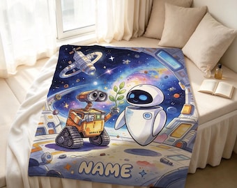 Könnte beinhalten: Eine rechteckige Wohndecke mit einer farbenfrohen Weltraumszene, die die Roboter Wall-E und Eve zeigt. Wall-E hält eine kleine grüne Pflanze in Richtung Eve vor einem Hintergrund aus Sternen, Planeten und einer Raumstation. Unten steht NAME.
