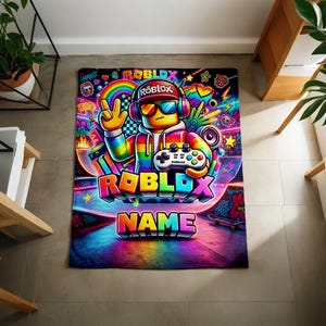 May include: A rectangular blanket featuring a vibrant, multi-colored graphic of a Roblox character wearing headphones and sunglasses, holding a game controller. The design includes the text ROBLOX and NAME, surrounded by neon rainbows, stars, and graffiti.