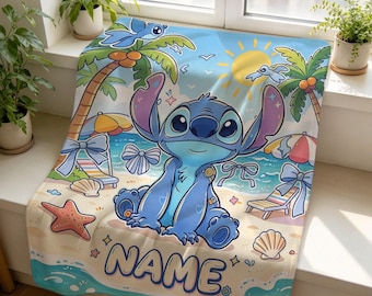 Könnte beinhalten: Eine weiche Decke mit einem blauen Alien-Charakter, der an einem Sandstrand mit Palmen, einer gelben Sonne und Meereswellen sitzt. Das Design umfasst Strandstühle, Muscheln, einen Seestern und blaue Schleifen. Das Wort NAME ist in großen Buchstaben aufgedruckt.