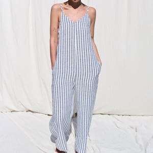 Puede incluir: Un mono de lino a rayas blancas y azules con tirantes finos. El mono tiene cuello en V y bolsillos a los lados.