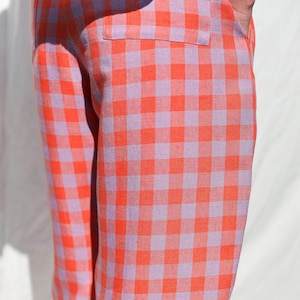 May include: Orange and purple gingham pants with a wide leg silhouette.