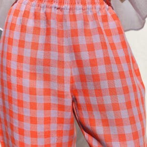 May include: Orange and purple gingham pants with an elastic waistband.