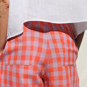May include: A pair of orange and purple gingham pants with a patch pocket on the back.