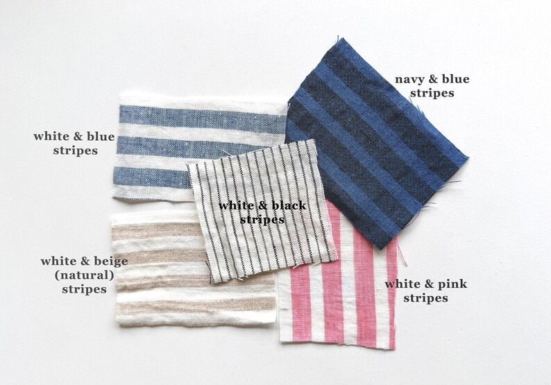 May include: Five rectangular fabric swatches featuring various striped patterns. The swatches include white & blue stripes, navy & blue stripes, white & black stripes, white & beige (natural) stripes, and white & pink stripes, each labeled with its color combination.