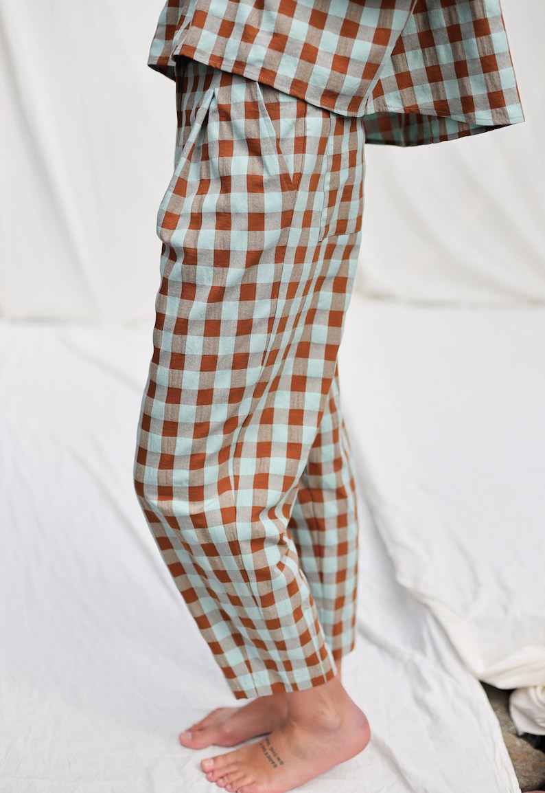 May include: Brown and light blue checkered pants with a wide leg and a cropped length.