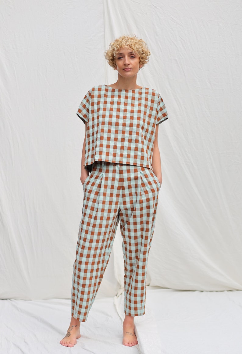 May include: A brown and light blue gingham patterned top and pants set. The top has short sleeves and a relaxed fit. The pants have a high waist and a straight leg.
