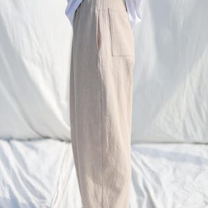 Puede incluir: Un pantal&oacute;n de lino beige claro con cintura de cord&oacute;n y un solo bolsillo de parche en la parte posterior.