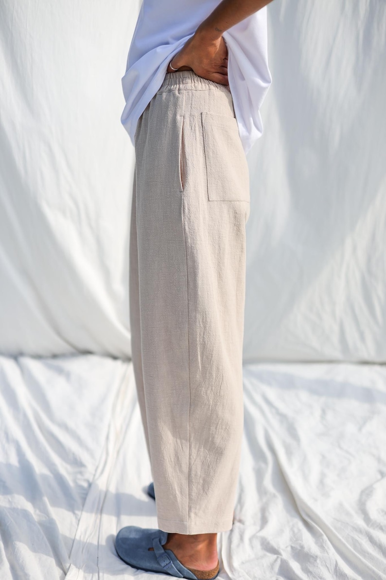 Puede incluir: Un pantal&oacute;n de lino beige claro con cintura de cord&oacute;n y un solo bolsillo de parche en la parte posterior.