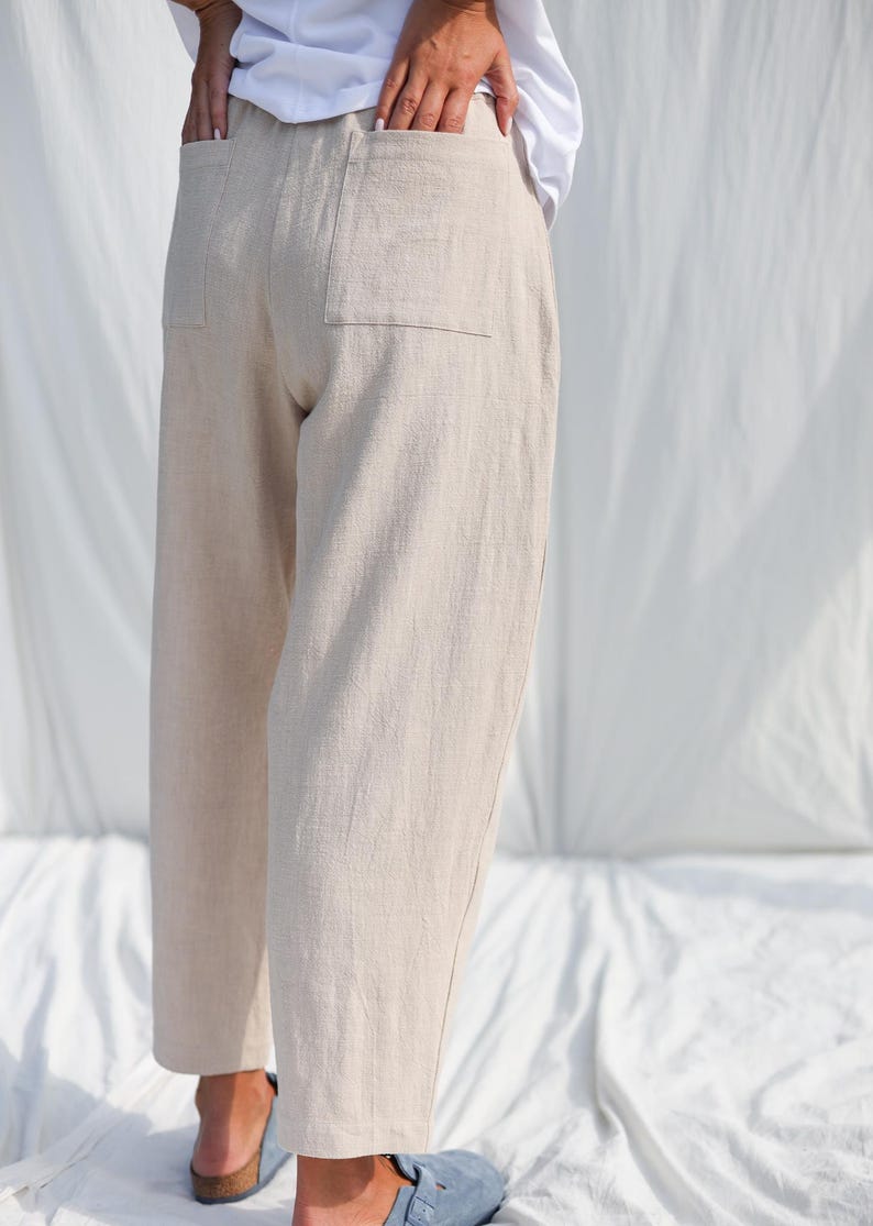 Puede incluir: Un pantal&oacute;n de lino beige con un bolsillo trasero. El pantal&oacute;n es corto y tiene un corte holgado.
