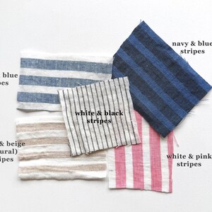 Puede incluir: Cinco muestras de tela con diferentes patrones de rayas. Las muestras son blancas y azules, blancas y beige, blancas y negras, azul marino y azules, y blancas y rosas.