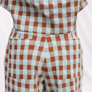 May include: A pair of brown and light blue gingham shorts with two patch pockets in the back.