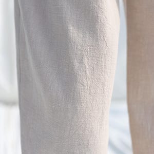 Puede incluir: Primer plano de la textura de la tela de un pantal&oacute;n beige claro.