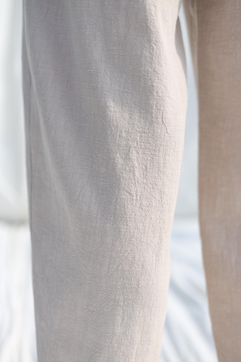 Puede incluir: Primer plano de la textura de la tela de un pantal&oacute;n beige claro.