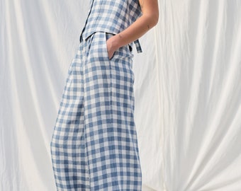 May include: A blue and white gingham sleeveless top and wide-leg pants set. The top has a V-neck and buttons down the front. The pants have a high waist and a wide leg.