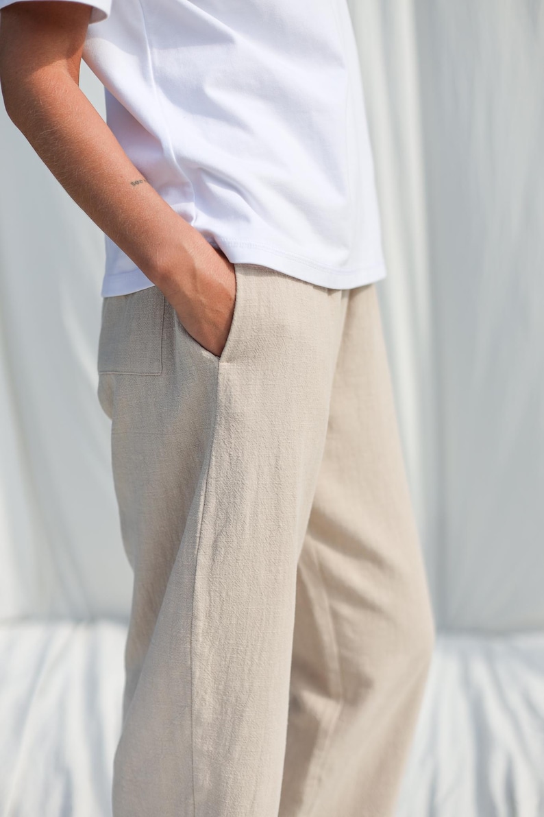 Puede incluir: Pantal&oacute;n de lino beige con un bolsillo delantero. El pantal&oacute;n es holgado y tiene una silueta relajada.