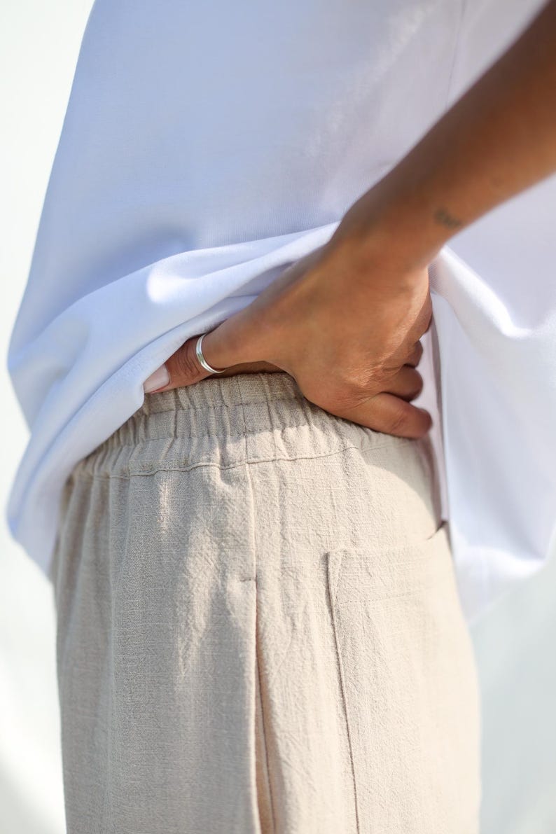Puede incluir: Pantal&oacute;n de lino beige con cintura el&aacute;stica y un bolsillo en la parte posterior.