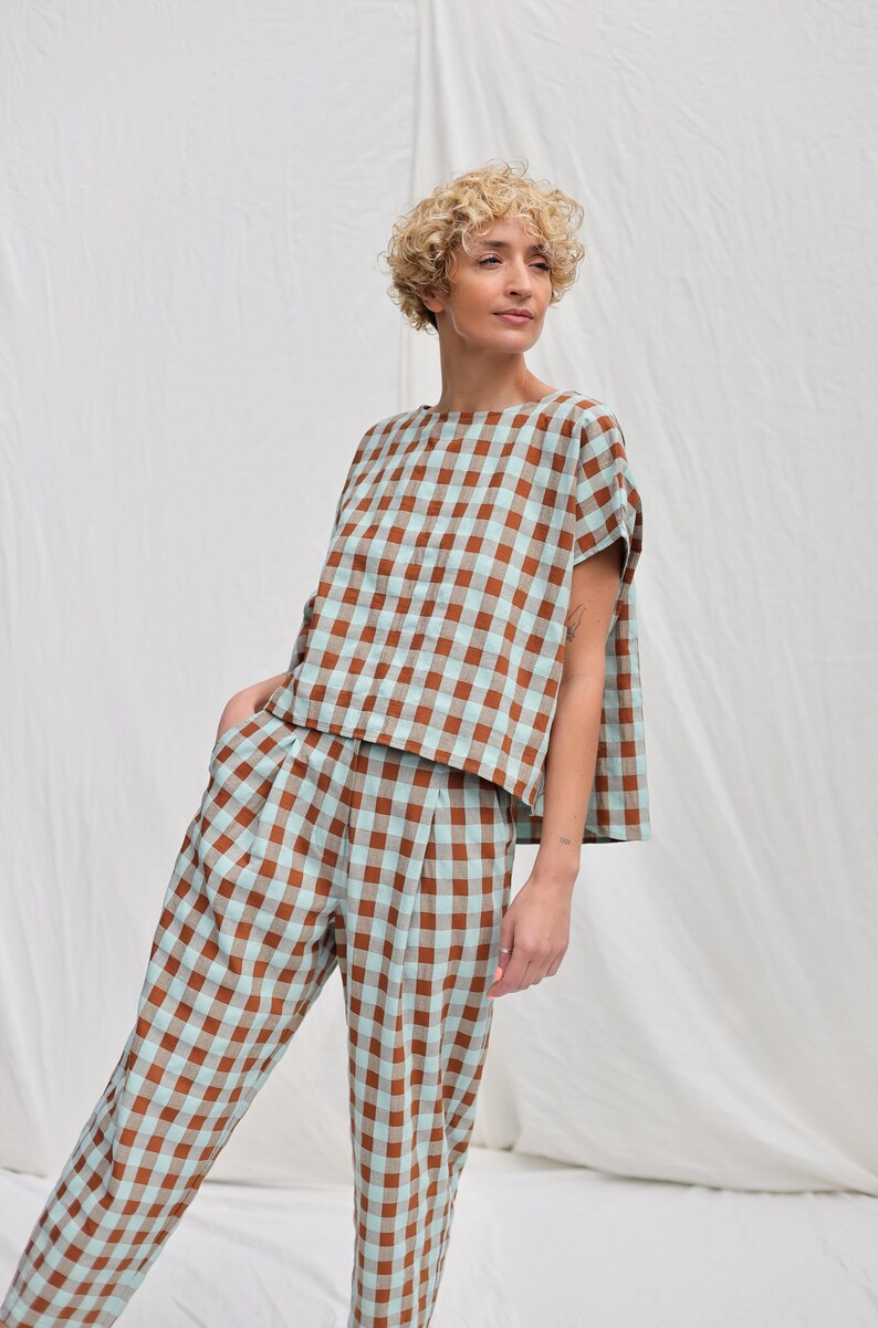 May include: A brown and light blue gingham patterned top and pants set. The top has a relaxed fit and short sleeves. The pants have a high waist and a straight leg.