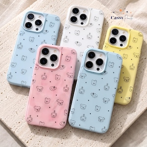 May include: Five smartphone cases in light blue, white, pink, and yellow, each featuring a repeating pattern of small black line-art dog faces and dots. The cases have cutouts for camera lenses and the text Cassy Pouch is printed in the top right.