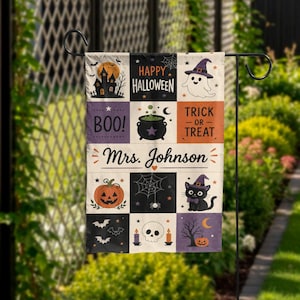 May include: A rectangular garden flag featuring a grid of Halloween-themed illustrations including a haunted house, a ghost, a cauldron, a pumpkin, a spiderweb, a black cat, a skull, and bats. The text reads Happy Halloween, Boo, Trick or Treat, and Mrs. Johnson.