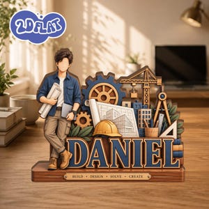 May include: A multi-layered wooden desk sign featuring a figure holding blueprints and a tablet, next to a gear, construction crane, hard hat, and drafting tools. The name DANIEL is displayed in large blue letters, with the text BUILD DESIGN SOLVE CREATE.