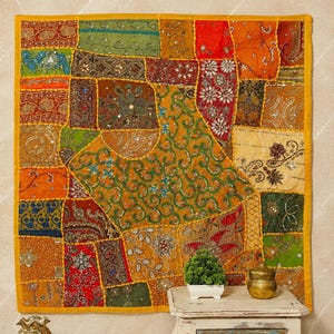 Könnte beinhalten: Ein quadratischer Wandbehang aus einem Patchwork aus bunten Stoffbahnen in Orange, Gelb, Grün, Rot und Blau. Das Textil ist mit aufwendigen Stickereien, metallischen Fäden und kleinen reflektierenden Spiegelakzenten verziert.