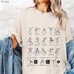 Puede incluir: Una camiseta de manga corta color marfil con un estampado gráfico de figuras de palo realizando diversas funciones y ecuaciones matemáticas. El diseño incluye etiquetas como y=e, y=ln(x), y=x, y=lx!, y=sqrt(x), y=sin(x), y=cos(x), y=tan(x), y=1/x, y=a y fórmulas de cálculo.