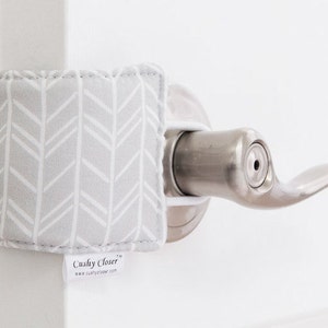 May include: A gray and white chevron patterned doorstop with the text "Cushy Closer" and the website "www.cushycloser.com".