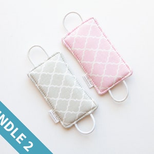 May include: A set of two doorstops, one in pink and one in gray, with a geometric pattern. The doorstops are made of fabric and have a loop handle.