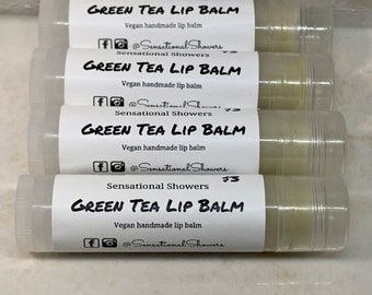May include: Four white tubes of green tea lip balm with a white label that says "Green Tea Lip Balm" and "Vegan handmade lip balm". The label also includes the social media handle "@SensationalShowers".