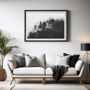 Photographie en noir et blanc d'une forêt enveloppée de brume. Les arbres apparaissent à travers un voile de brouillard, créant une ambiance apaisante et mystérieuse.