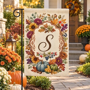 May include: A rectangular garden flag featuring a central brown letter S inside an ornate frame, surrounded by a colorful autumn-themed border of sunflowers, chrysanthemums, blue and green pumpkins, acorns, berries, and fall-colored leaves.