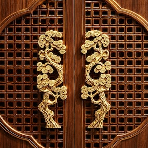 May include: A pair of vertical door handles crafted from polished gold-toned metal, each featuring a detailed relief sculpture of a pine tree with textured bark and circular needle clusters, mounted on dark brown wooden doors with a grid pattern.