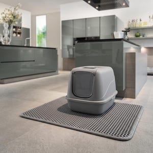 May include: A light gray enclosed cat litter box with a front-entry door and a removable top lid, positioned on top of a rectangular gray litter trapping mat featuring a honeycomb-patterned surface texture for catching loose debris.