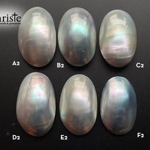 May include: Six oval-shaped iridescent white mother of pearl cabochons, labeled A2, B2, C2, D2, E2, and F2.