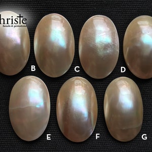 May include: Seven oval-shaped iridescent white mother of pearl cabochons labeled A through G.