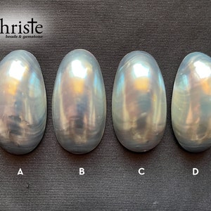 May include: Four iridescent oval-shaped stones labeled A, B, C, and D. The stones have a pearly white and gray color with a subtle shimmer.