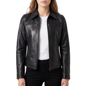 May include: A black leather jacket featuring a classic collar, a full-length front zipper, and two horizontal zippered chest pockets. The jacket has long sleeves with zippered cuffs and a tailored fit, worn over a plain white t-shirt and black pants.