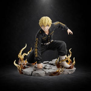 以下が含まれることがあります： 金髪のアニメキャラクターのフィギュア。金色の日本語の刺繍が入った黒い制服を着て、ひび割れた灰色の石の台座にしゃがみ込んでいる。半透明のオレンジ色の炎のエフェクトに囲まれ、白いブーツを履き、大きく笑っている。