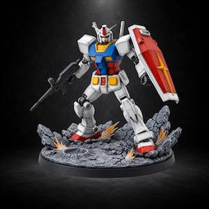May include: A white, blue, red, and yellow robot action figure standing on a rocky, cratered base. The figure holds a black rifle in one hand and a red and white shield with a yellow star emblem in the other, featuring detailed panel lines.