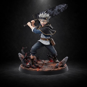 Puede incluir: Una figura detallada de estilo anime de un personaje con cabello blanco puntiagudo, vistiendo una túnica negra y azul con capa, sosteniendo una gran espada negra desgastada sobre el hombro. La figura se apoya en una base agrietada y ardiente.