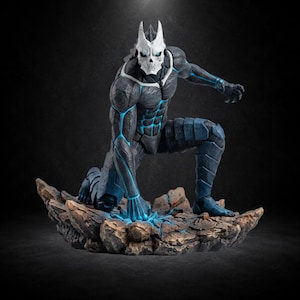 Könnte beinhalten: Eine Sammlerfigur eines muskulösen humanoiden Wesens in hockender Pose, das eine weiße totenkopfartige Maske und einen dunkel strukturierten Anzug mit leuchtend blauen Linien trägt, platziert auf einem felsigen, unebenen Sockel mit Lichteffekten.