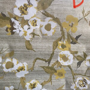 May include: A beige fabric with a white and yellow floral pattern. The fabric has a subtle texture and a slightly distressed look.